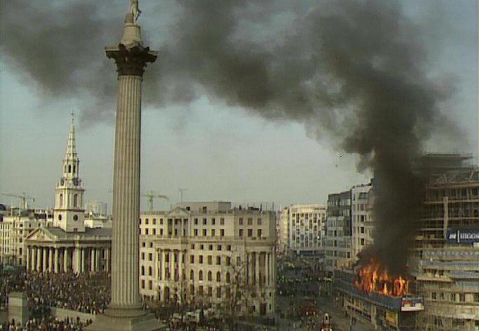 Trafalgar Square, 31 March 1990: Chaos and fire surrounding the scaffolding of Grand Buildings.